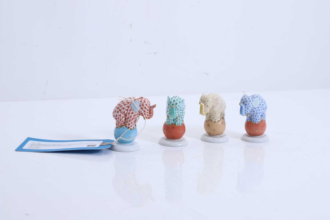 Four Herend model elephants,: Four Herend model elephants, each balancing on a ball, and with harlequin pattern decoration, all with blue stamped marks to the base 7cm high 4