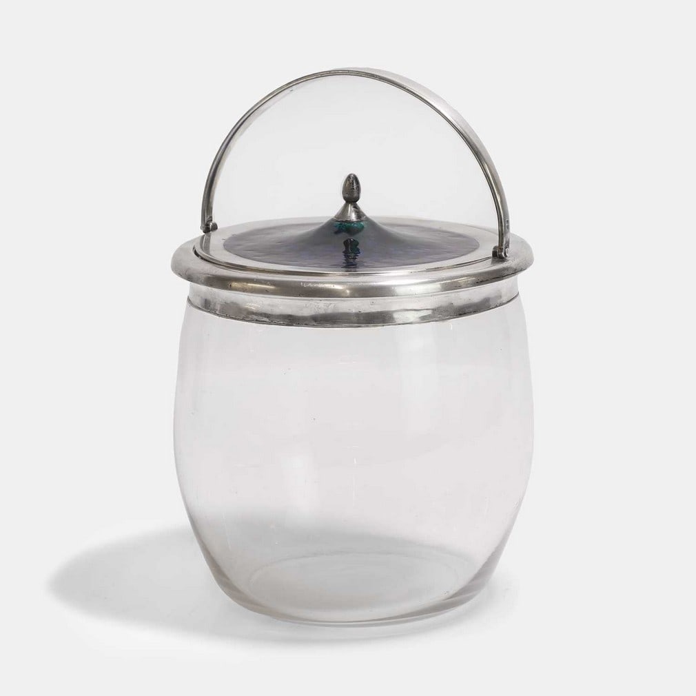 Archibald Knox (British, 1864-1933) for Liberty & Co., a biscuit barrel,: Archibald Knox (British, 1864-1933) for Liberty & Co., a biscuit barrel, 1905, stamped for Birmingham, the glass body mounted with a silver handle and detachable lid, decorated with blue and green ena