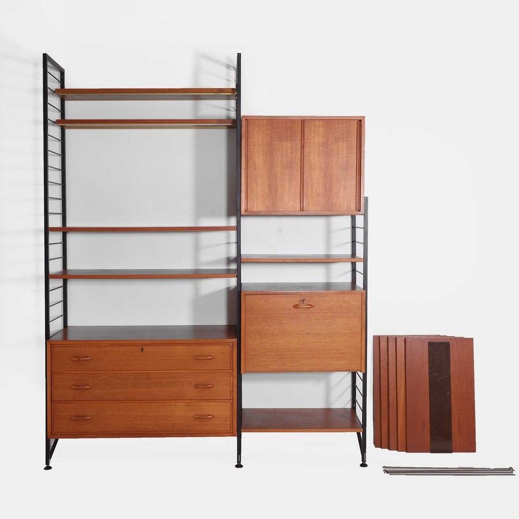 Ladderax, a teak modular shelving unit,: Ladderax, a teak modular shelving unit, circa 1960s, comprising three black-painted metal ladders, eleven shelves, a drop-down-front cupboard, and a cupboard with a sliding door opening to a unit with