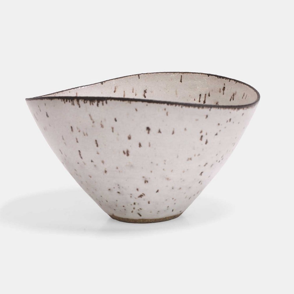 ▲ Dame Lucie Rie (Austrian, 1902-1995), a 'squeezed' stoneware bowl,: ▲ Dame Lucie Rie (Austrian, 1902-1995), a 'squeezed' stoneware bowl, circa 1955-60, with oatmeal glaze and manganese rim, impressed maker's mark (14cm diameter, 9.5cm high) Provenance: The colle
