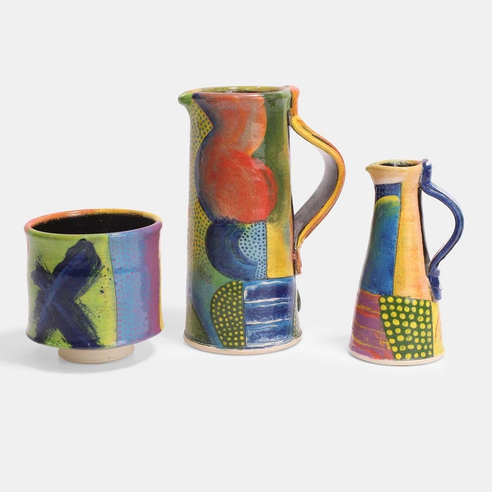 John Pollex (British, b.1941), a group of three ceramics,: John Pollex (British, b.1941), a group of three ceramics, comprising two jugs and a tea bowl, slipware covered in polychrome decoration, each with impressed maker's mark (largest (jug) 11cm wide, 8cm