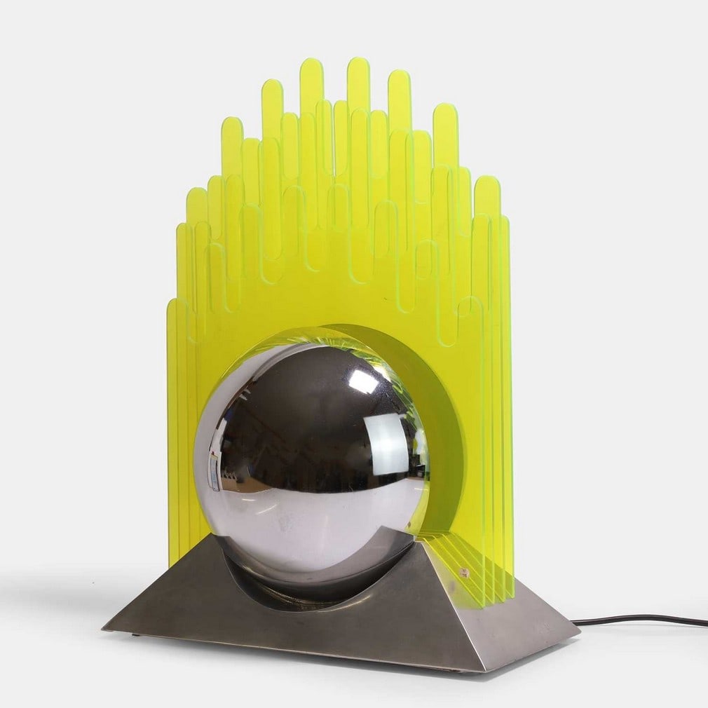 Gae Aulenti (Italian, 1927-2012), a table lamp,: Gae Aulenti (Italian, 1927-2012), a table lamp, circa 1970, yellow acrylic, chrome-plated steel, and aluminium, probably manufactured for New Lamp (40.5cm wide, 20cm deep, 52cm high) Footnote: Literat