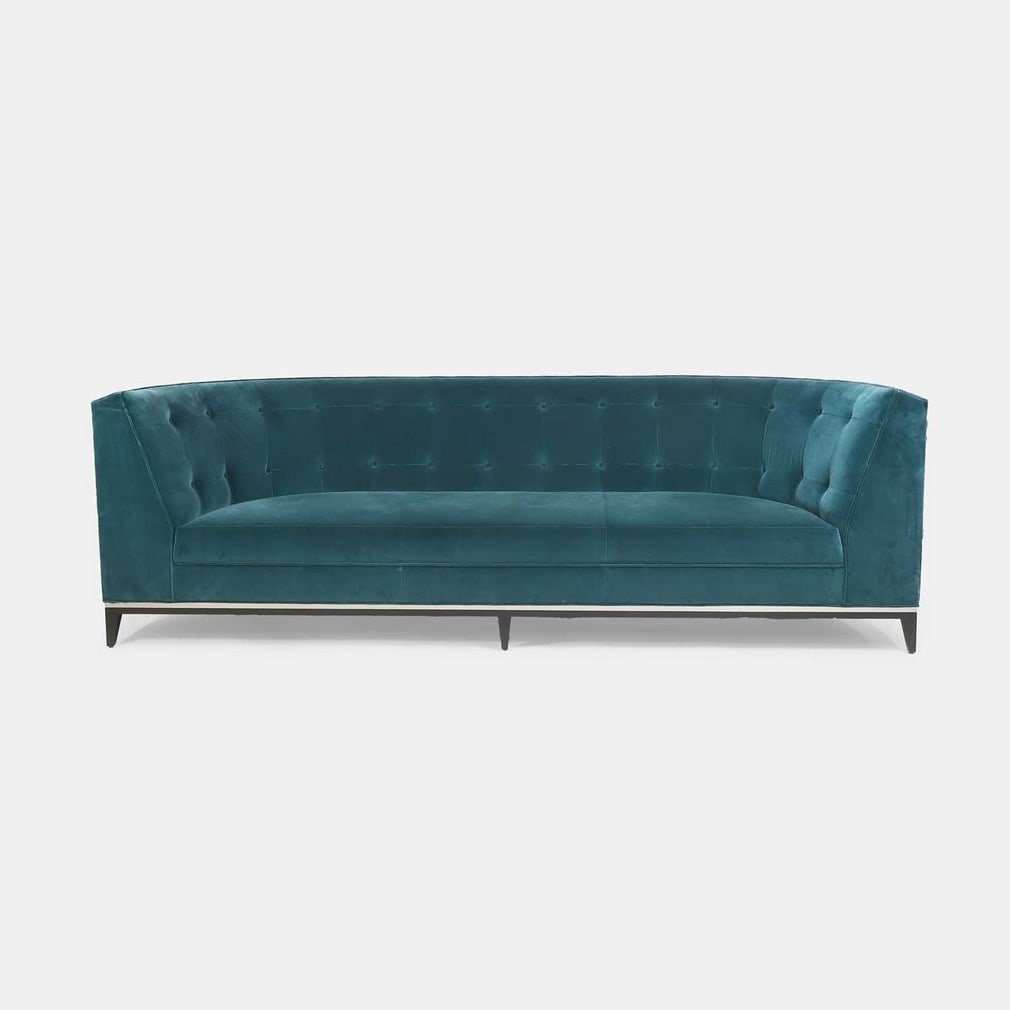 Amy Somerville, a sofa,: Amy Somerville, a sofa, of recent manufacture, with curved edges, upholstered in teal velvet with a button back, raised on six lacquered and ebonised tapered feet, with chrome strip detailing (252cm w