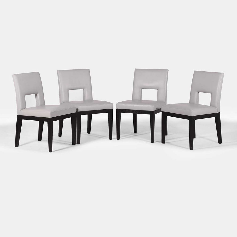 Christian Liaigre (French, 1943-2020), a set of four 'Velin' chairs,: Christian Liaigre (French, 1943-2020), a set of four 'Velin' chairs, originally designed in 1998, each with a pierced back and seat, upholstered in grey leather, raised on four ebonised oak tapered le