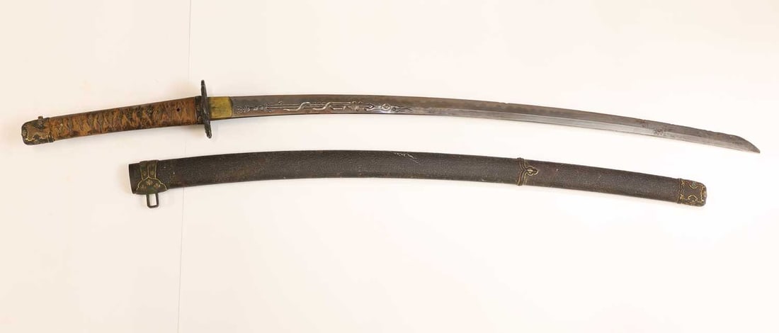 A Japanese Wakizashi, Edo period,: A Japanese Wakizashi, Edo period, the black saya (scabbard) with a signed kazuka, the handle decorated with a dragon entwined around a sceptre, mounted with a white same (shagreen) tsuka (handle)