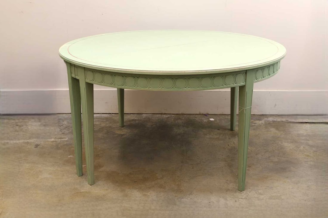 A painted extending dining table, modern,: A painted extending dining table, modern, the round top painted in celadon green, with a narrow red border, above a frieze decorated with repeating paterae, raised on moulded tapered supports, with