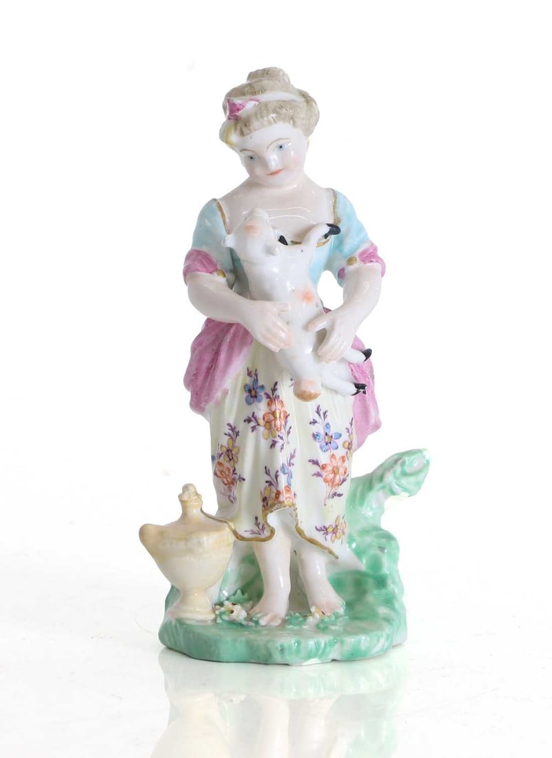 A Derby figure of a young girl with a lamb, 19th century,: A Derby figure of a young girl with a lamb, 19th century, modelled standing barefoot upon a naturalistic mound base applied with flowers and foliage, the young girl wearing a blue and pink bodice,