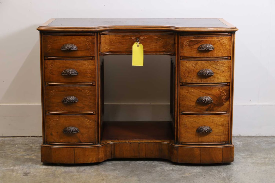 A Victorian walnut pedestal desk, mid-19th century,: A Victorian walnut pedestal desk, mid-19th century, with a leather inset top, with an inverted bow front, the central drawer, the top of the lock plate inscribed to the top 'A.J. Gilham, Manufacturer