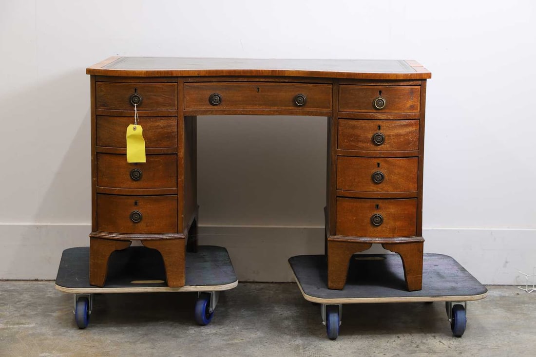 A mahogany inverted front pedestal desk, 20th century,: A mahogany inverted front pedestal desk, 20th century, of serpentine outline, the top inset with a green tooled leather writing surface above a long frieze drawer and an arrangement of drawers to eac