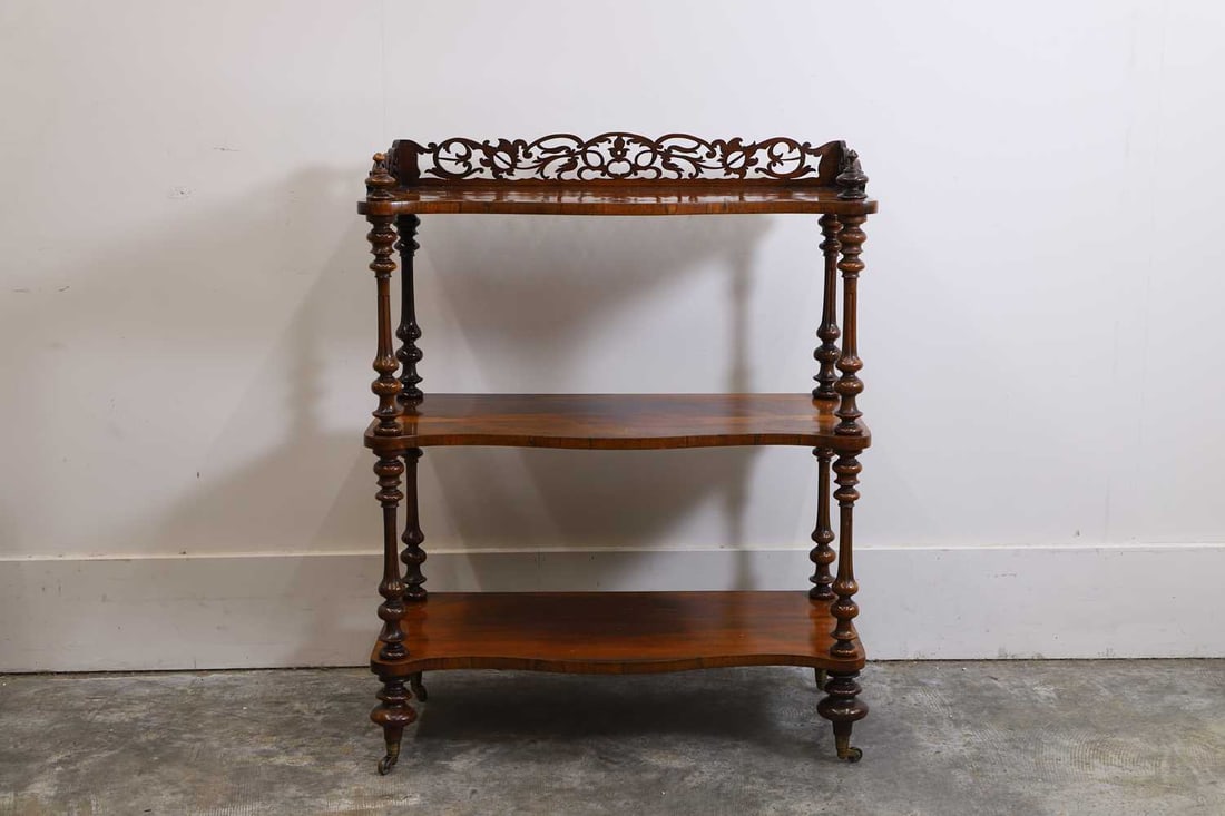 A Victorian rosewood whatnot, mid-19th century: A Victorian rosewood whatnot, mid-19th century with a fret cut three-quarter gallery, three serpentine fronted tiers, with turned supports and castors, 76cm wide, 37cm deep, 95cm high1Condition Repor