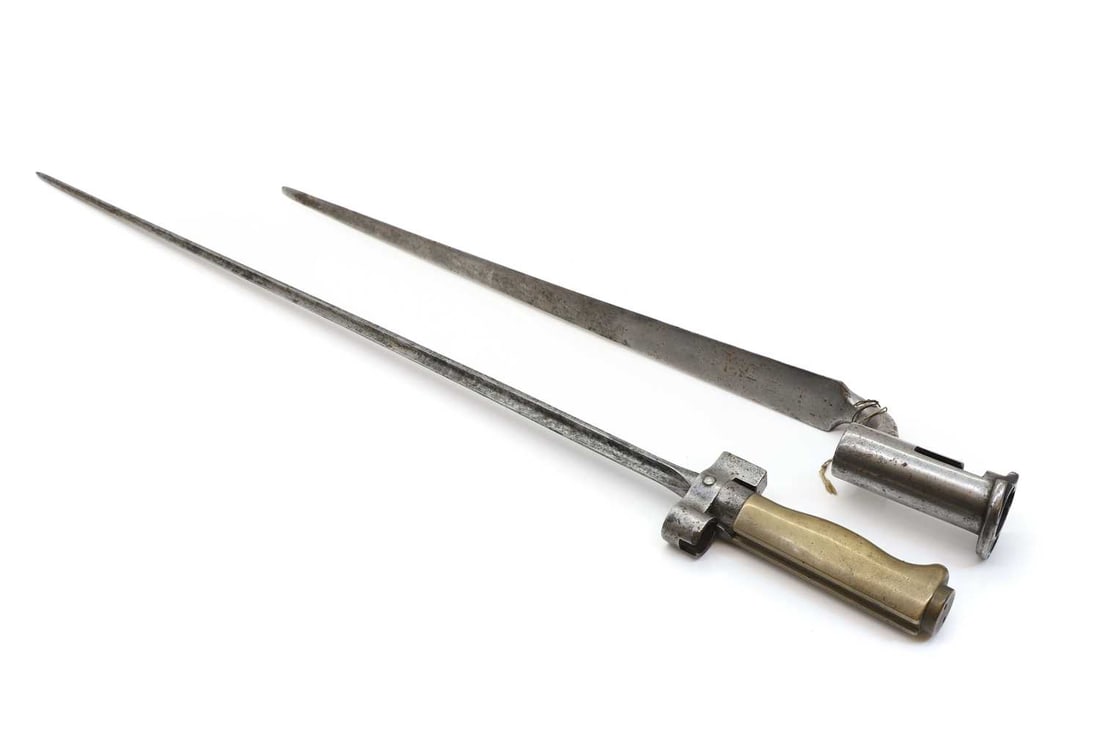 A French Lebel bayonet,: A French Lebel bayonet, M1886, with a cruciform blade, together with a Brown Bess steel socket bayonet, Shipping Disclaimer: Buyers must be aware of their country’s shipping and import policie