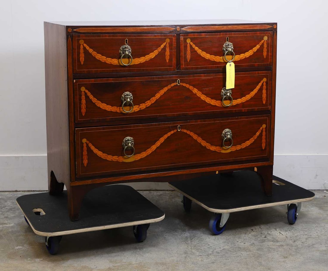 A mahogany and boxwood inlaid chest of four drawers, 20th century,: A mahogany and boxwood inlaid chest of four drawers, 20th century, the top inlaid with musical instruments, the drawer fronts, with inlaid swags and lion mask and hoop handles 99.5cm wide, 46cm deep,