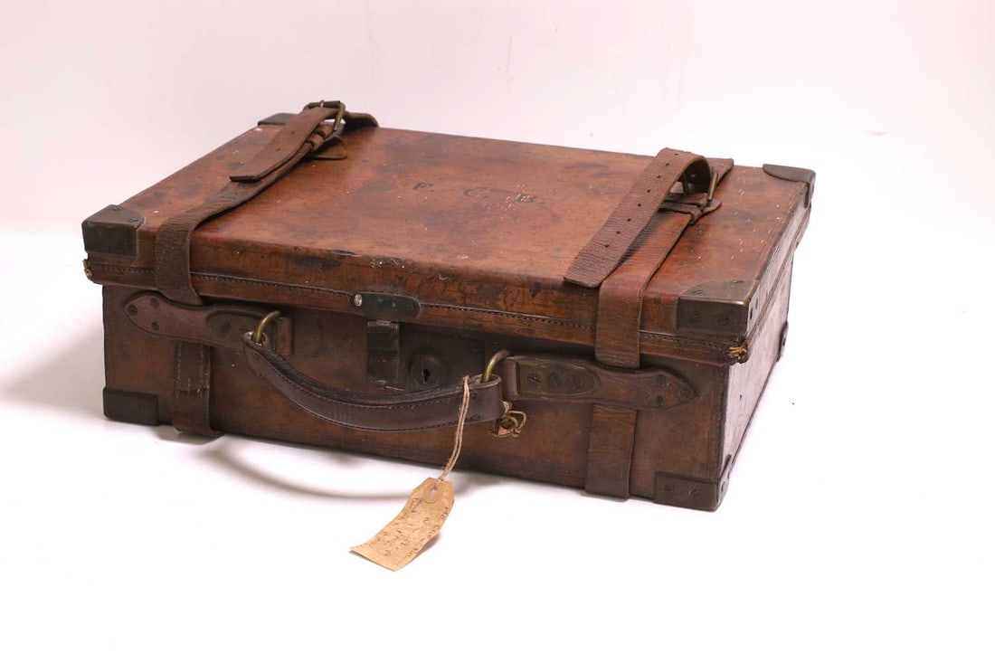 A leather cartridge magazine case by Purdy's, early 20th century,: A leather cartridge magazine case by Purdy's, early 20th century, with brass corners, lock, and leather straps, the top initialed 'F.C.B.', with a James Purdy retail tag to the interior of the lid, t