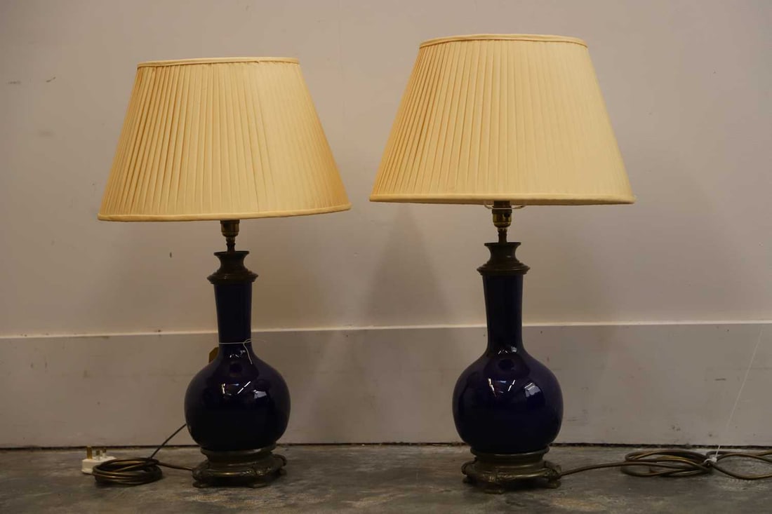 A pair of blue glazed table lamps, 20th century,: A pair of blue glazed table lamps, 20th century, each with pleated cream conical shades, terminating on bronzed bases with square feet 68cm high 2 Condition Report: Fair overall. We cannot