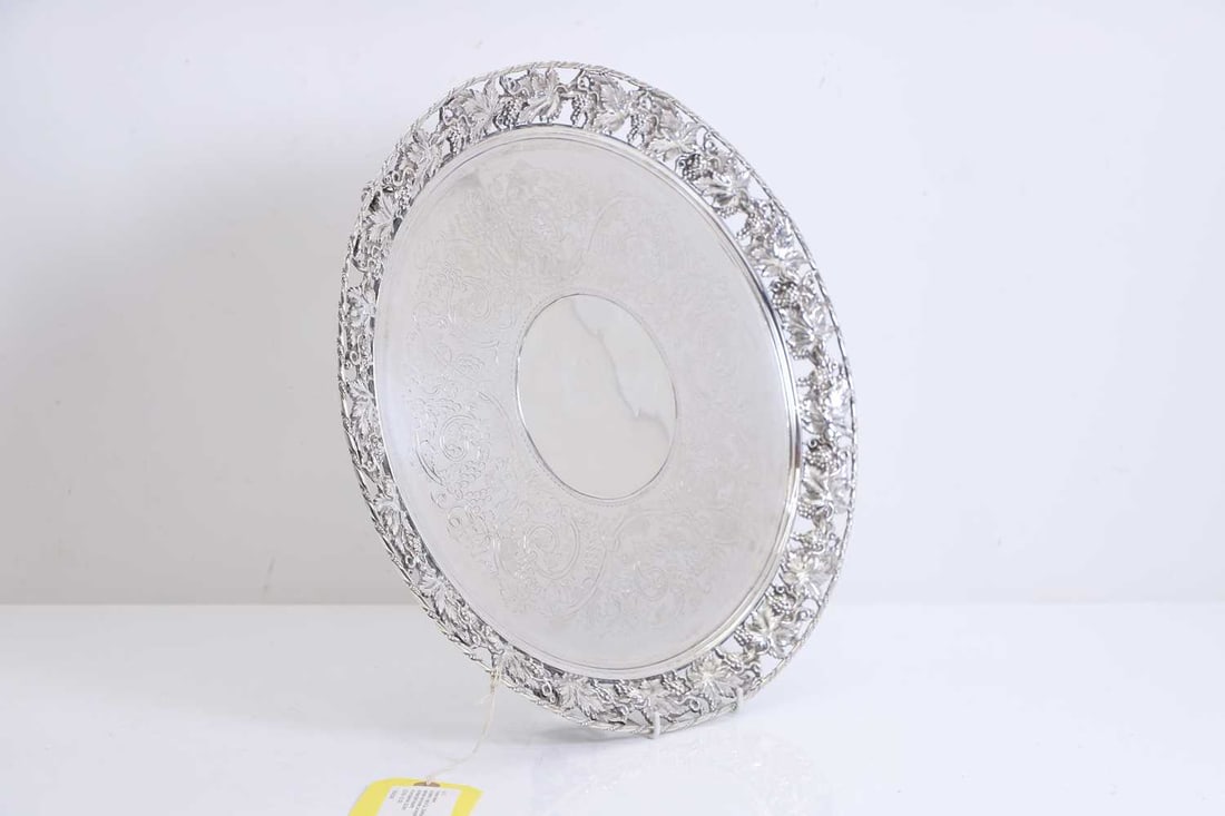 A silver salver,: A silver salver, by Martin, Hall & Co., Sheffield, 1863, of circular form, with a pierced vine border, an engraved centre, raised on pierced scrolled leaf supports 41cm diameter, 62.9oztCondition
