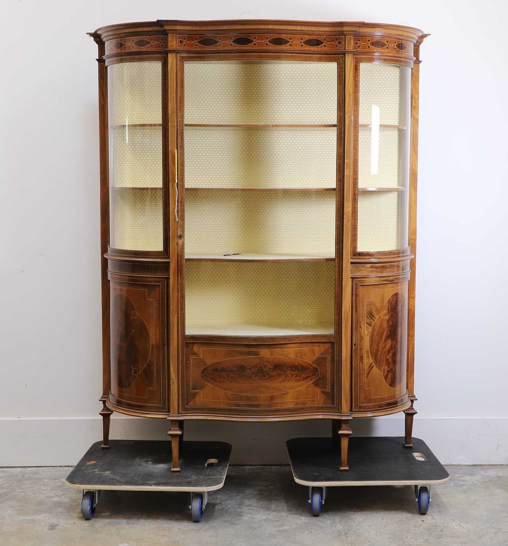 An Edwardian inlaid mahogany display cabinet circa 1900,: An Edwardian inlaid mahogany display cabinet circa 1900, retailed by Maple & Co., fitted with three fabric-lined shelves, with a full-length cupboard, flanked with lower cupboards, labelled to