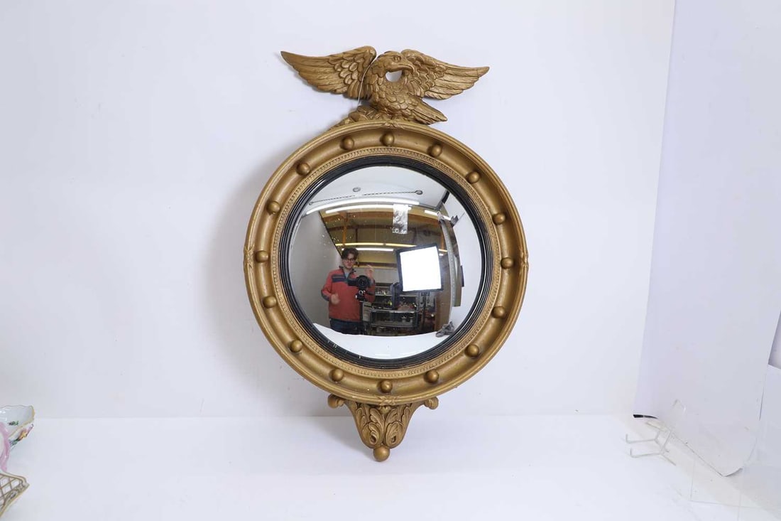 A gilt convex mirror, of modern manufacture,: A gilt convex mirror, of modern manufacture, with eagle surmount and beaded rim 47cm wide, 70cm high Condition Report: Modern, regilded