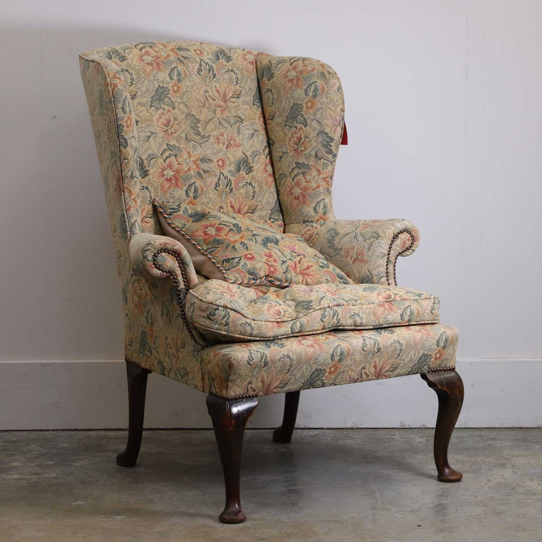 A Georgian mahogany wing armchair,: A Georgian mahogany wing armchair, upholstered in tapestry-type foliate fabric and raised on cabriole front legs and pad feet and splayed back legs and pad feet 88cm wide, 85cm deep, 114cm high,