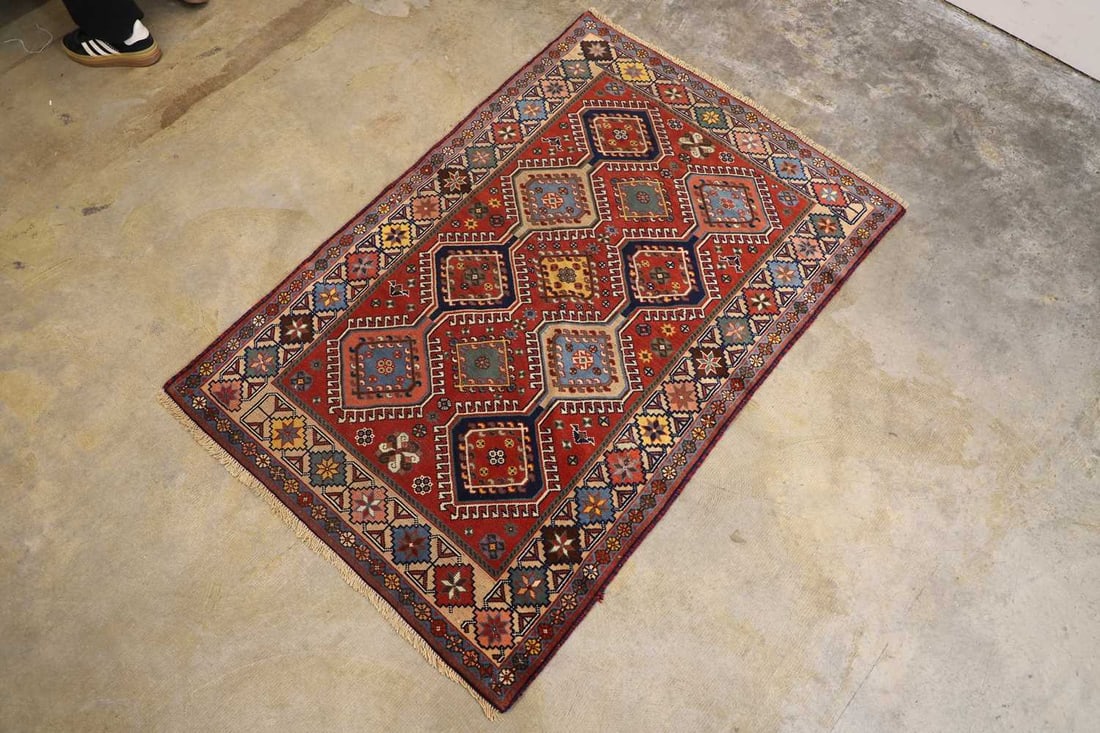 A small Persian rug, late 20th century,: A small Persian rug, late 20th century, the red ground with ten medallions to the central field, and floral banding 142 x 94cm Condition Report: Some pulls to the central field, the tassles cut.