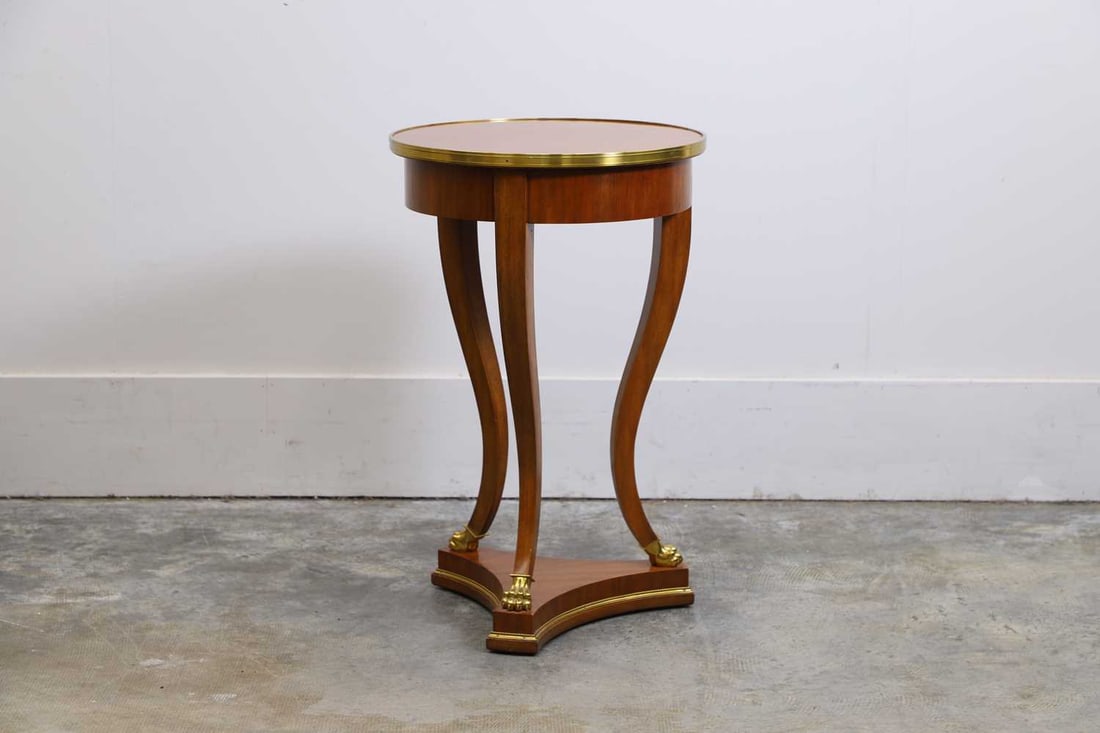 A modern Torchiere by Ralph Lauren, of modern manufacture,: A modern Torchiere by Ralph Lauren, of modern manufacture, with a circular top and brass banding, terminating on lion paw feet, and a shaped plinth base 45cm diameter, 71cm high
