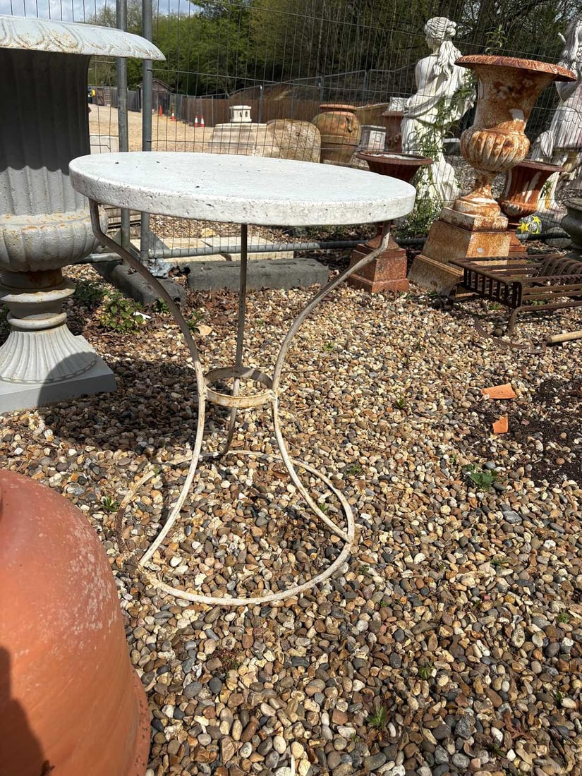 A painted metal garden table, 20th century,: A painted metal garden table, 20th century, the circular top of composite stone, raised on a painted metal base with four downswept supports united by a circular stretcher 57cm diameter, 75cm