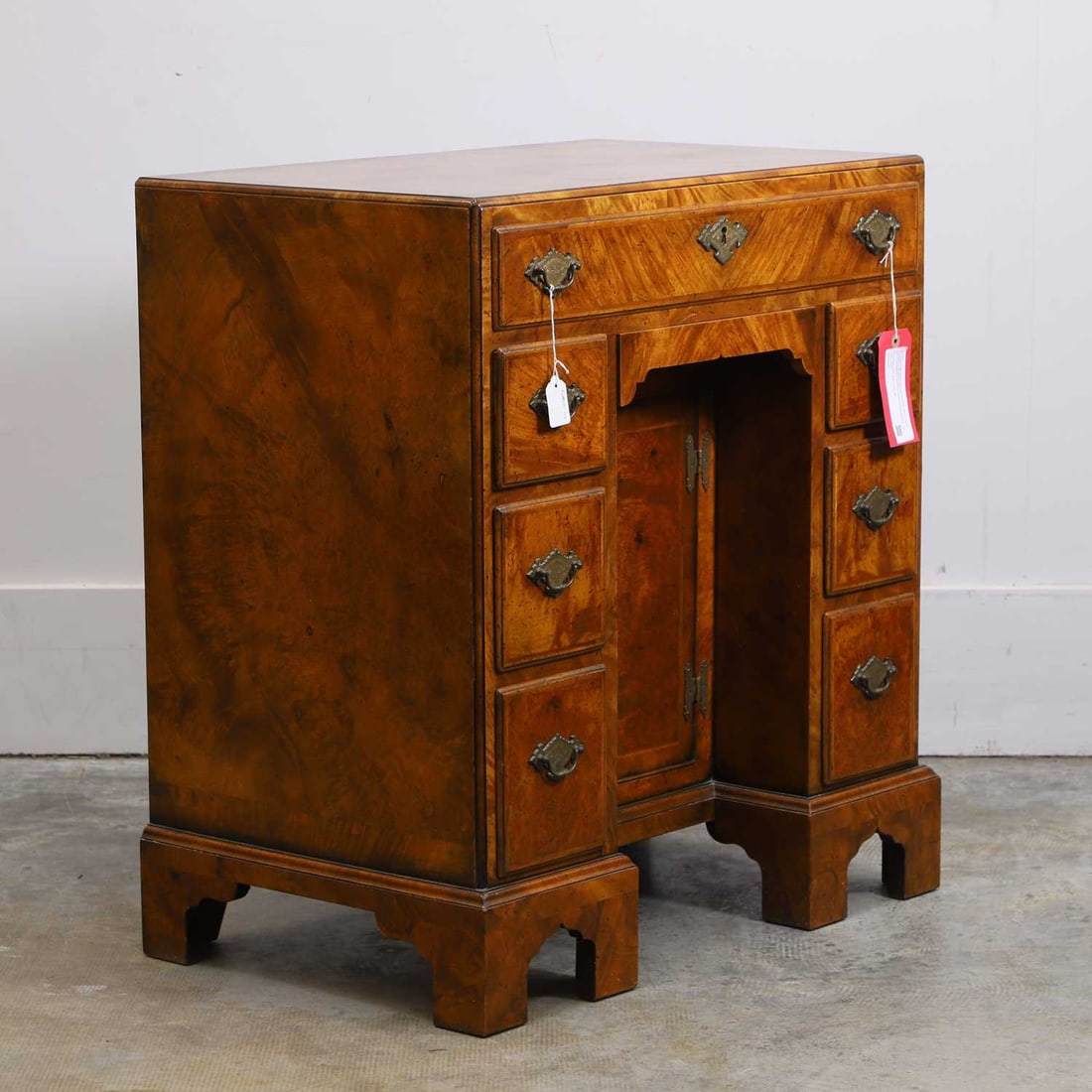 A George II style walnut caddy top kneehole desk, of recent manufacture, by David Coleman,: A George II style walnut caddy top kneehole desk, of recent manufacture, by David Coleman, with an arrangement of drawers fitted with brass handles, and a central cupboard door 77cm wide, 49cm