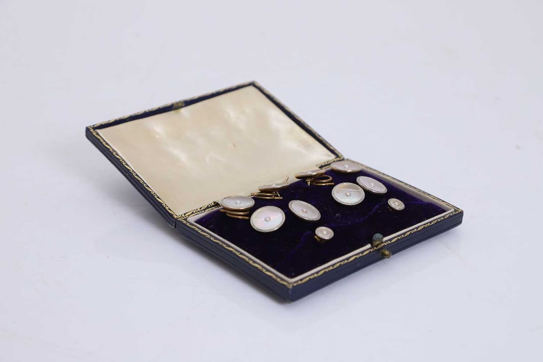 A cased set of 18ct gold and mother of pearl dress studs,: A cased set of 18ct gold and mother of pearl dress studs, comprising four buttons with removable clips, a pair of cufflinks and two dress studs, each mother of pearl plaque with a central split