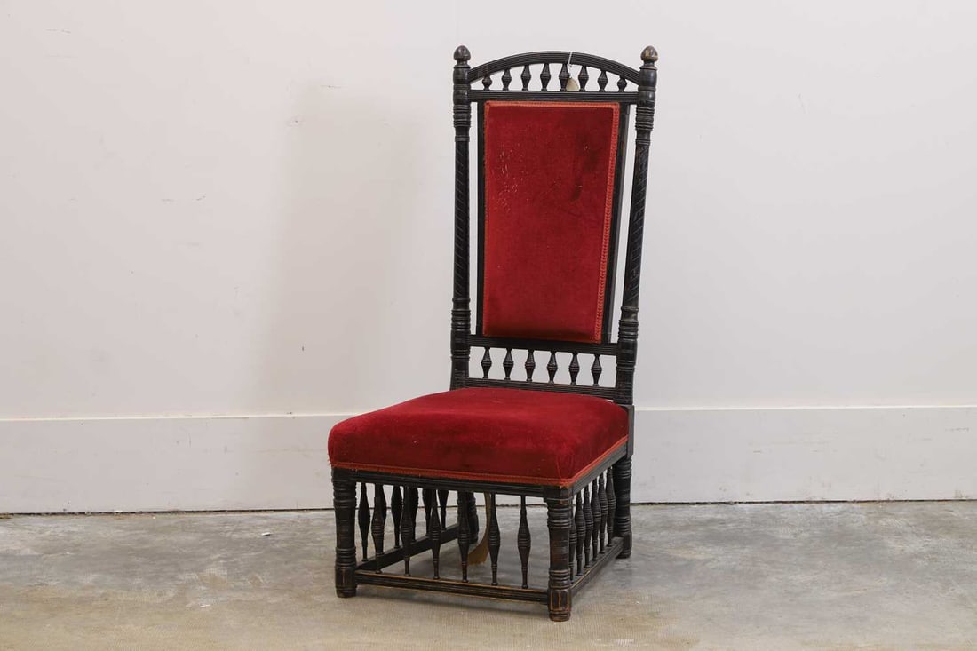 An Aesthetic Movement ebonised armchair, c.1875-80,: An Aesthetic Movement ebonised armchair, c.1875-80, the top of the back splat with turned finials, the arched support over further turned detailing 51cm wide, 55cm deep, 102cm high