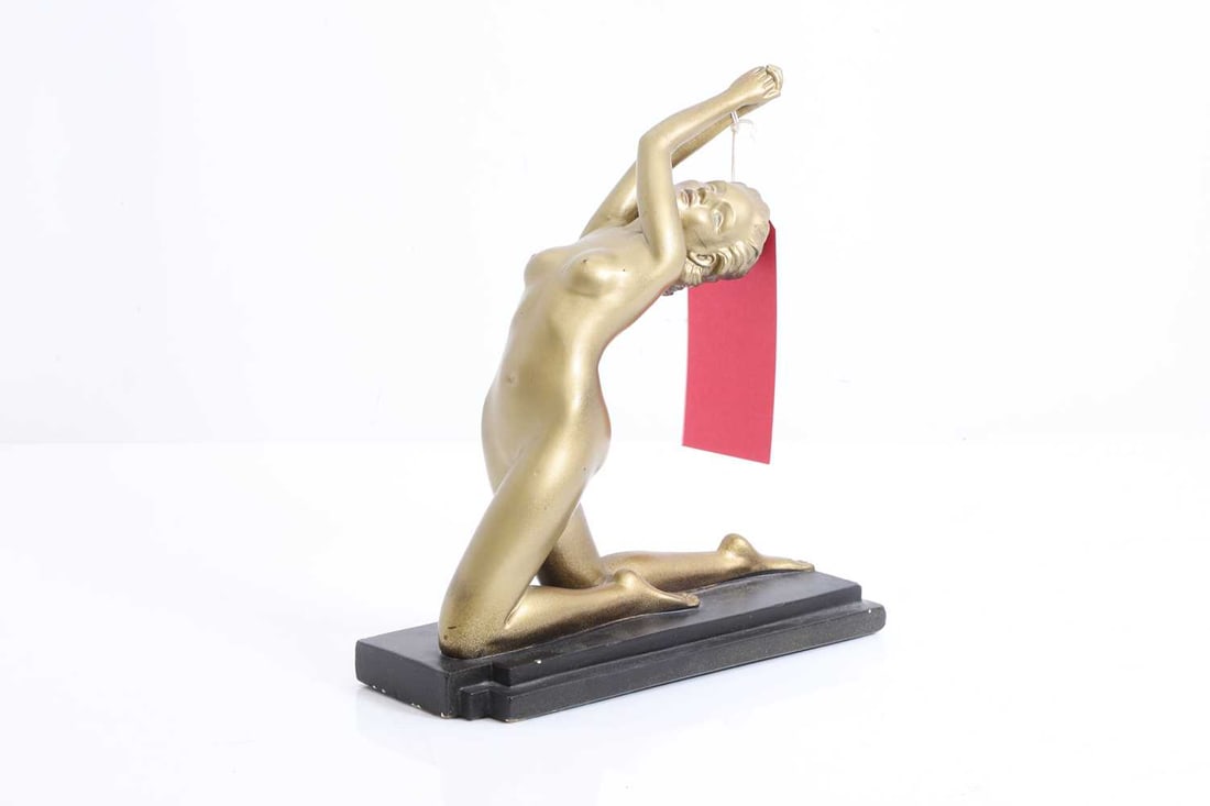 An Art Deco style gilded figure, late 20th century,: An Art Deco style gilded figure, late 20th century, depicting a kneeling woman with raised arms, with registration number to the base RD 809193 27cm high, 25cm wide