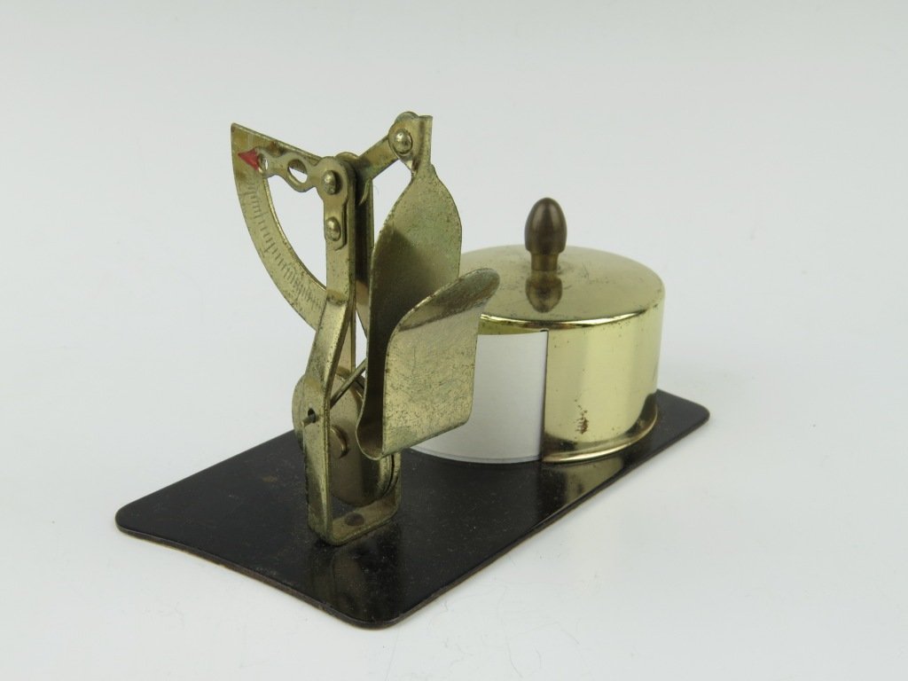 A brass pendulum letter scale, upon a shaped base with: A brass pendulum letter scale, upon a shaped base with address label dispenser, capacity 2oz