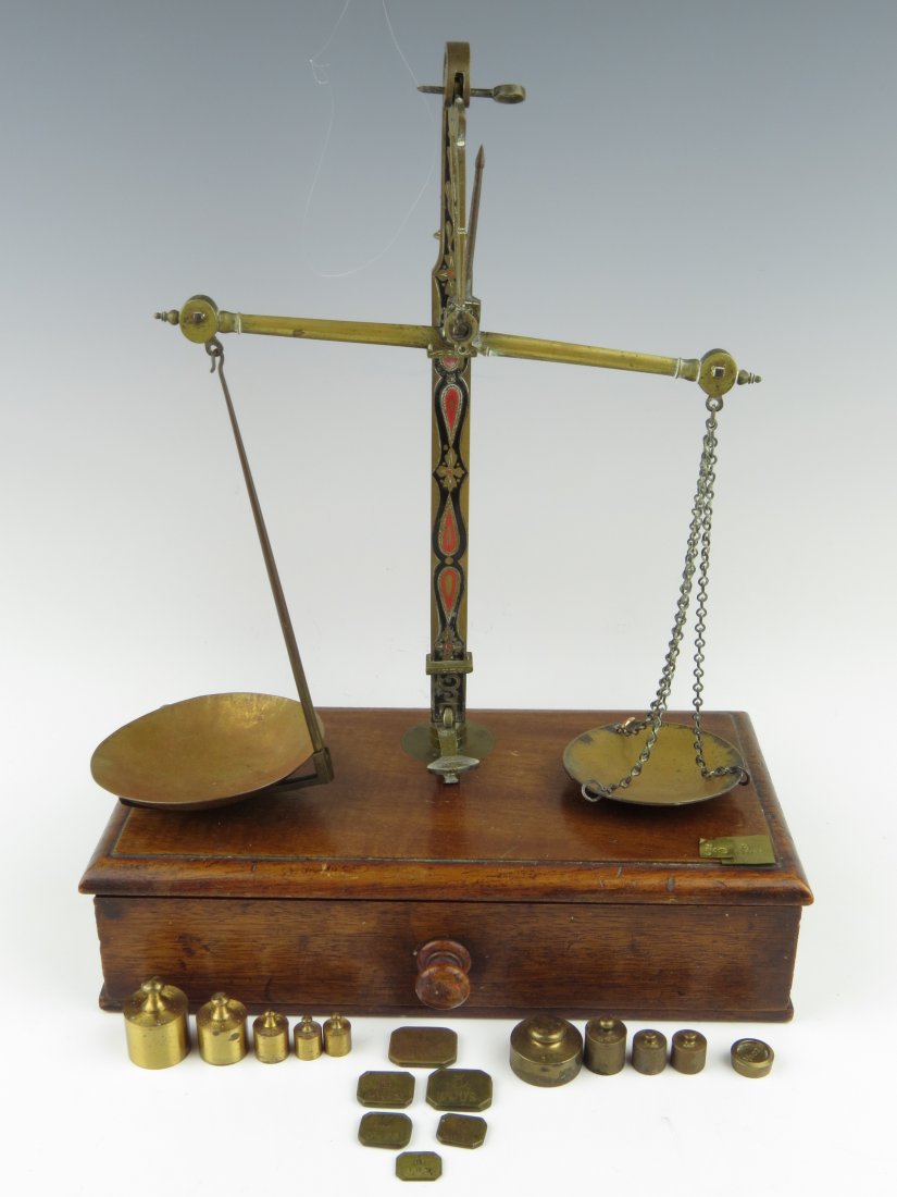 Apothecary scales, 19th century, the beam with box end: Apothecary scales, 19th century, the beam with box ends, supporting a brass and a copper pan, with arrestment pedal, the copper pan resting in a folding arm, all upon a mahogany base with plush lined 