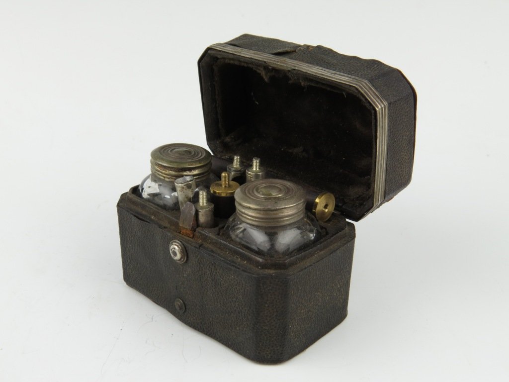 A travelling writing box, early 19th century, the poli: A travelling writing box, early 19th century, the polished shagreen covered box with silver coloured metal mounts opening to reveal two glass inkwells, a two-piece screw together pen holder with four 