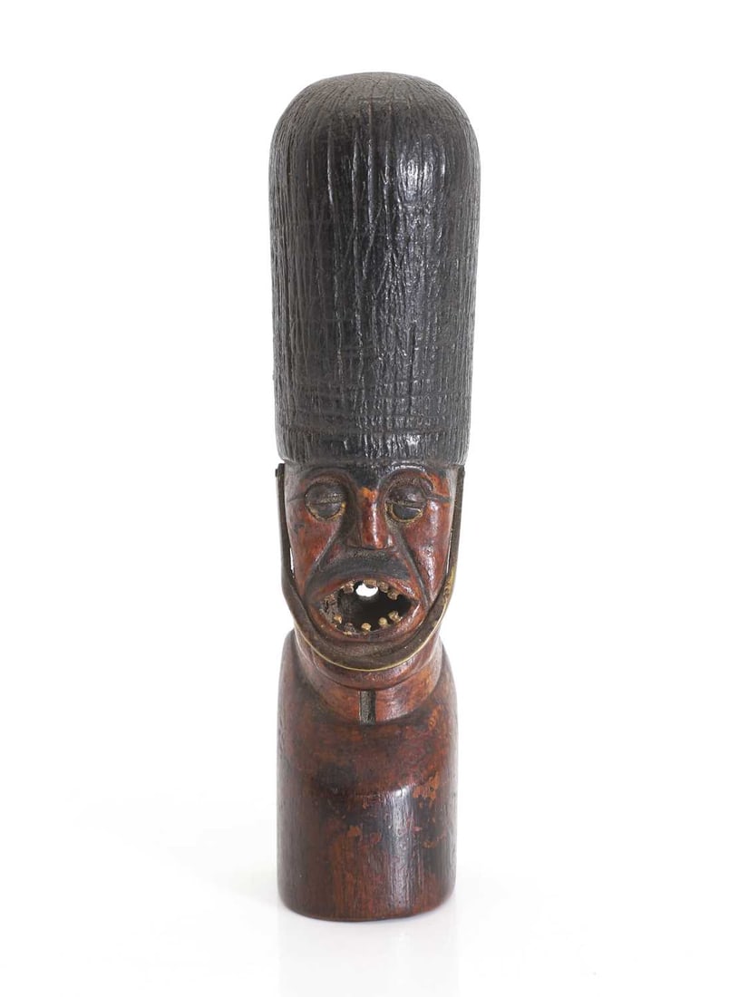 A trench art figural carving,: A trench art figural carving, possibly modelled as the King's guard, with mouth open 4.2cm wide, 16.5cm high Condition Report: Some chipping to the paint and knocks, scratches, and dents to the wood