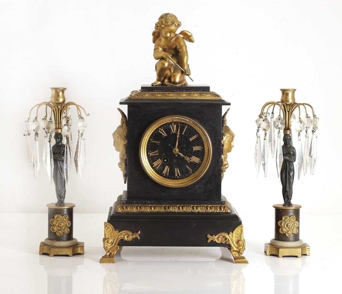 A black marble and gilt metal mantel clock, 19th century,: A black marble and gilt metal mantel clock, 19th century, with a cupid surmount, and a Roman chapter ring, with 8-day movement, mechanism stamped but rubbed, together with a pair of associated