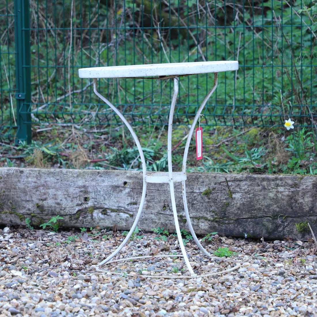 A painted metal garden table, 20th century,: A painted metal garden table, 20th century, the circular top of composite stone, raised on a painted metal base with four downswept supports united by a circular stretcher 57cm diameter, 75cm high9 Pr