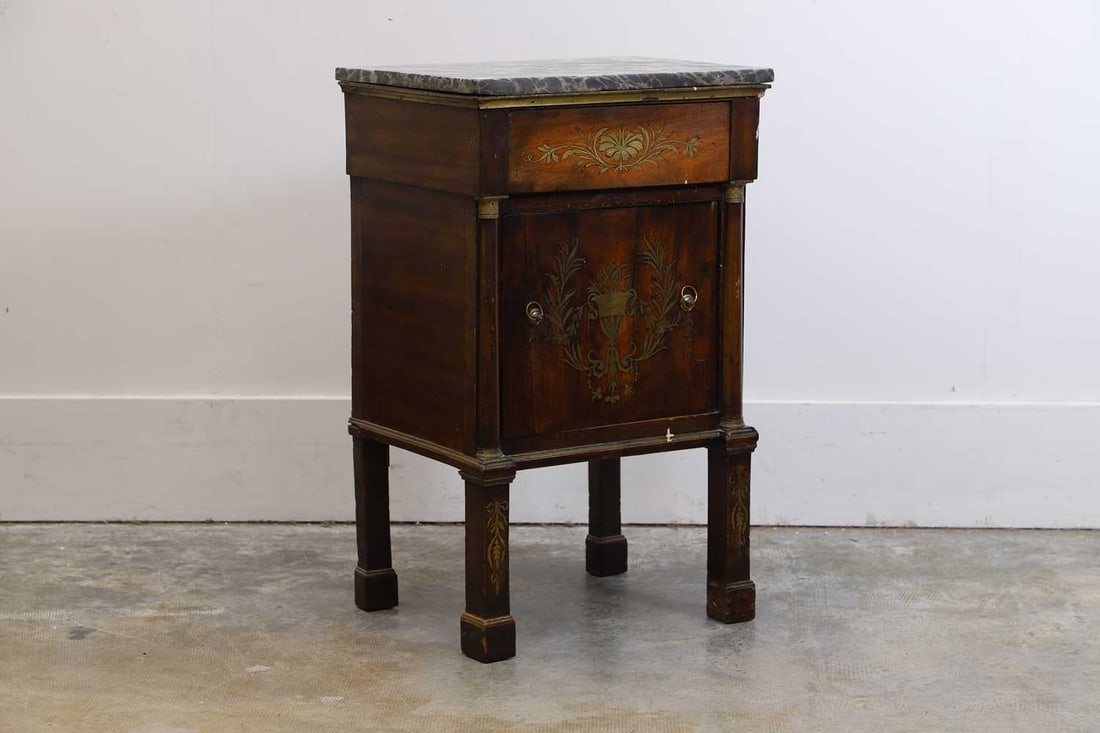 A French Empire mahogany and brass cabinet, c.1830,: A French Empire mahogany and brass cabinet, c.1830, with a veined grey marble top and brass inlaid detail to the door of a flowering urn 49cm wide, 80cm high Condition Report: With lifting to the
