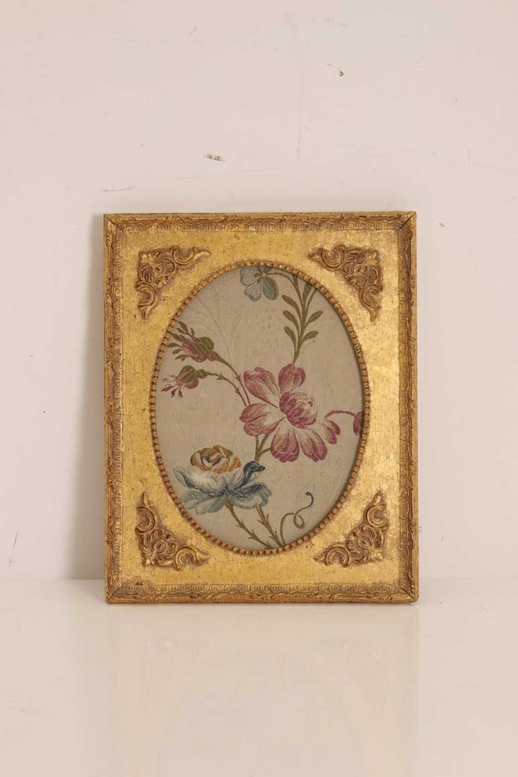 A floral woven silk panel, late 18th century,: A floral woven silk panel, late 18th century, of blossoming flowers framed in a gilt frame with foliate mounts, label to the reverse Framed 26 x 21cm Condition Report: Some knocks and chips to teh
