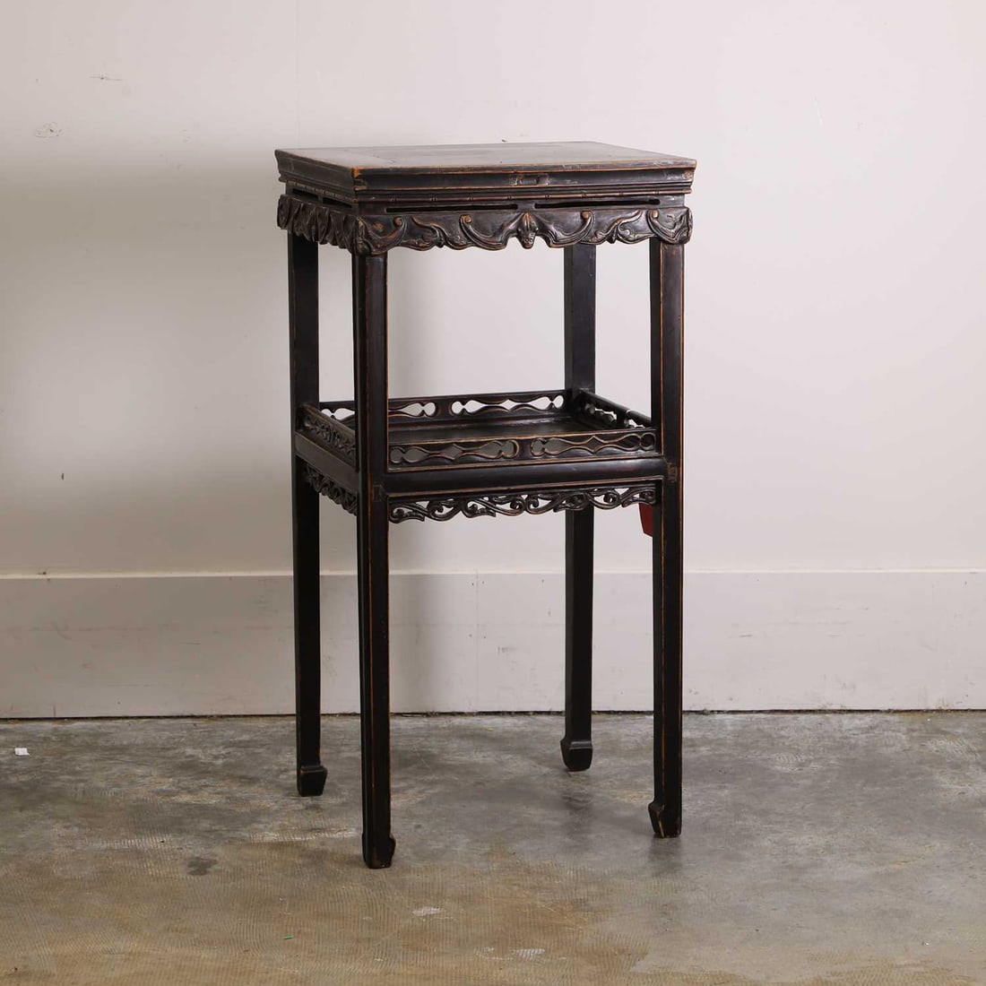 A hardwood jardiniere stand, late 19th / early 20th century, Chinese,: A hardwood jardiniere stand, late 19th / early 20th century, Chinese, carved throughout with ruyi bats, with a rectangular top above an undertier, set between moulded square supports 44cm wide, 37cm