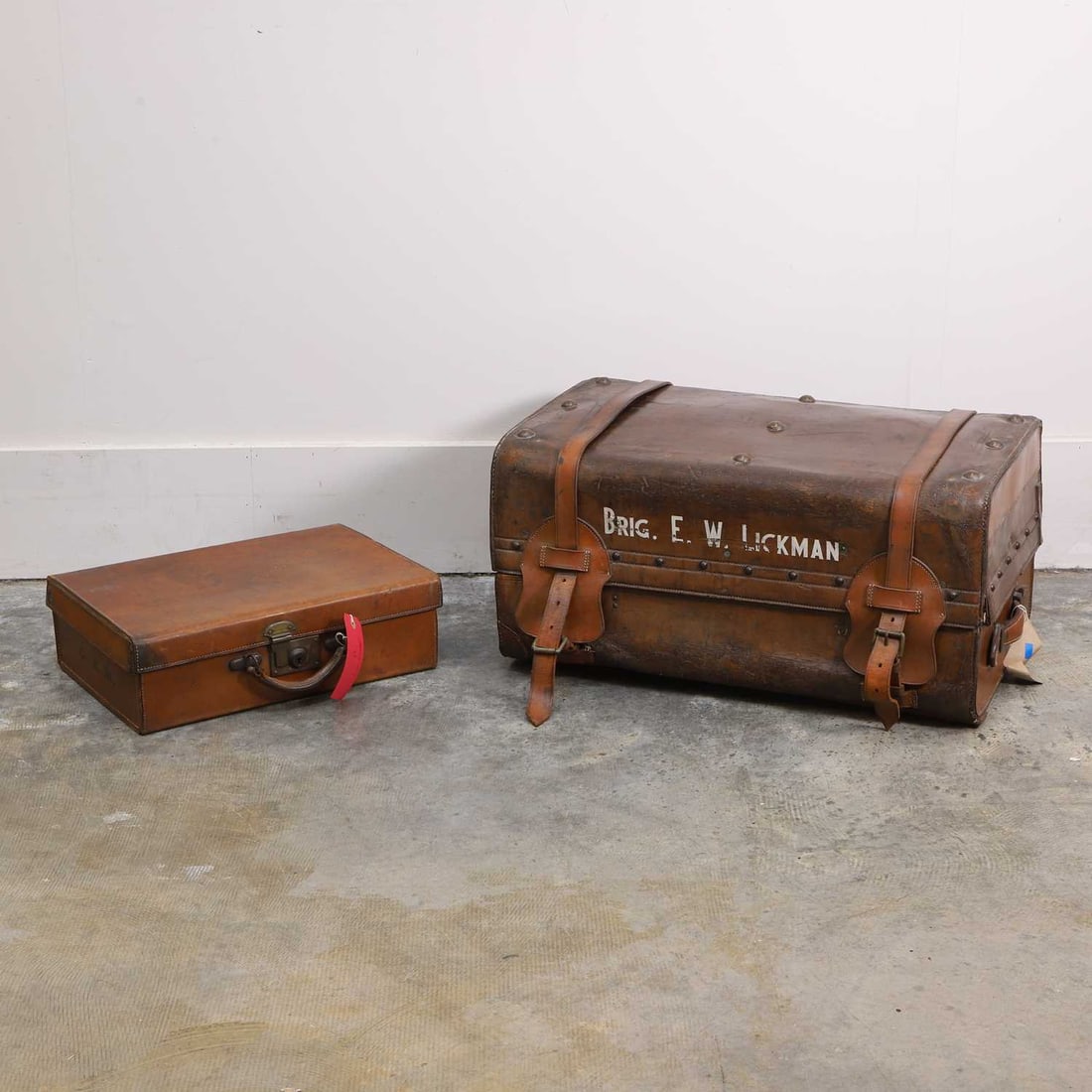 A leather travel trunk, late 19th century,: A leather travel trunk, late 19th century, with large straps that run the circumfrence of the case, and leather covered latches, each side with leather handles, the base with mahogany supports and
