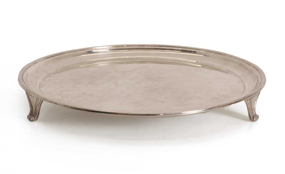 A silver salver,: A silver salver, by Roberts & Belk Ltd, Sheffield, 1972, of simple form with scrolled feet 25cm diameter, 16.5ozt
