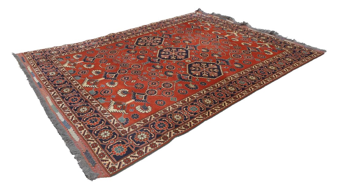 A Turkish wool rug, 20th century,: A Turkish wool rug, 20th century, with a red ground, dark blue border with repeating motfis surrounding a centre with three large medallions, roughly 257cm wide 234cm long