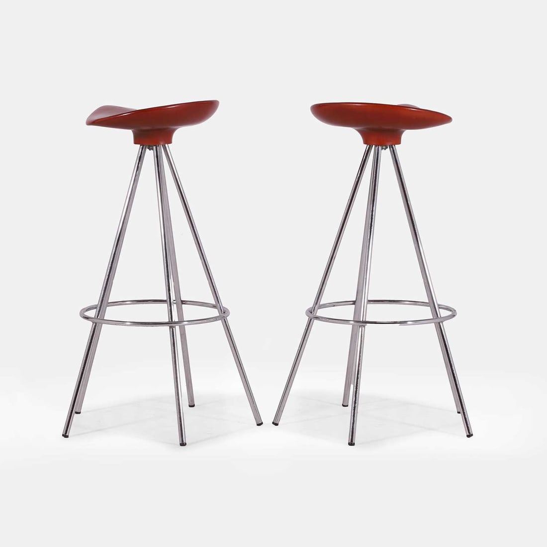 Pepe Cortés (Spanish, b.1946), a pair of stools,: Pepe Cortés (Spanish, b.1946), a pair of stools, 1990s, each of aluminium with a red-lacquered wood seat, with applied manufacturer's label 50cm wide, 50cm deep, 82cm high 2