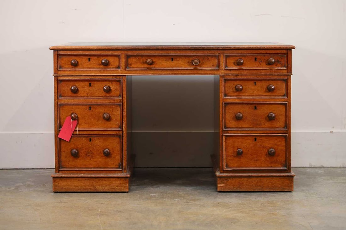 An oak pedestal desk, circa 1900,: An oak pedestal desk, circa 1900, with a green inset top, with an arrangement of nine drawers 122cm wide, 75cm deep, 74cm high 3 Condition Report: Knocks and wear. Handles with chips and losses.