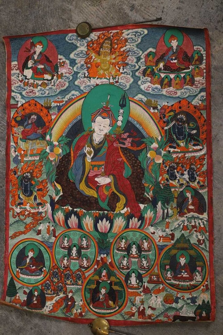 A Tibetan thangka, 20th century,: A Tibetan thangka, 20th century, of Padmasambhava, seated in lalitasana on a lotus base, holding a vajra in his right hand; in his left hand the skull bowl of absolute voidness, sur