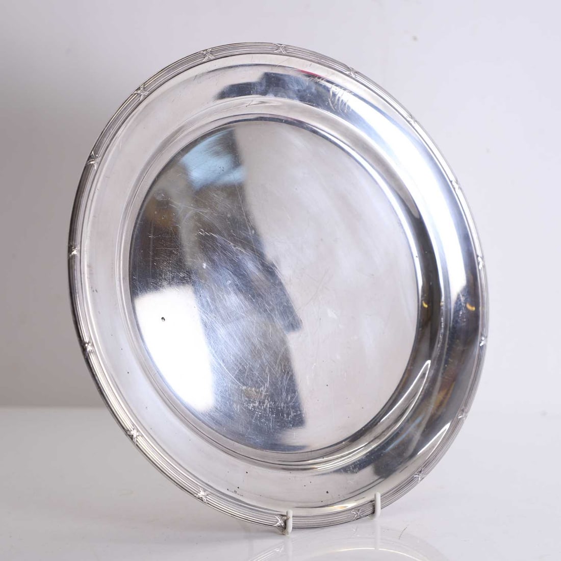 A silver-plated salver, 20th century,: A silver-plated salver, 20th century, of circular form with a gently raised and reeded rim, the rim with engraved initials 'LHA' 33cm diameter Condition Report: With tarnishing and surface scratches.