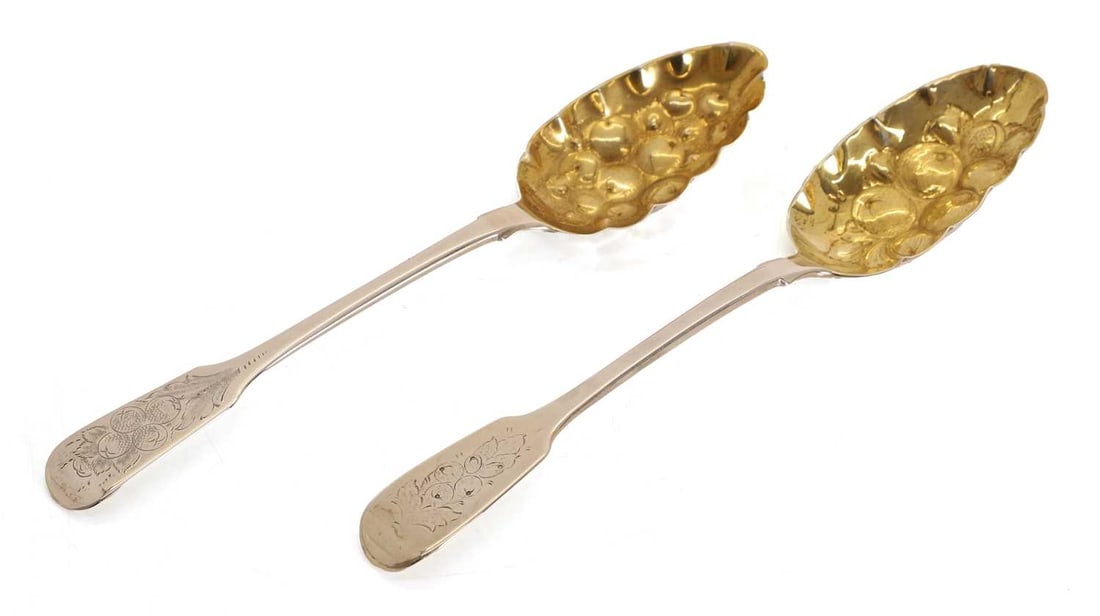 Two silver berry spoons,: Two silver berry spoons, by William Theobalds, London, 1837, with gilt bowls decorated with berries The largest 22.5cm long, 4.2ozt 2