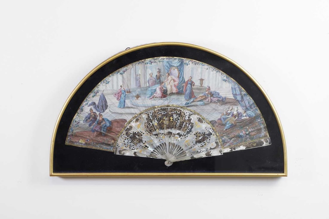 A mother-of-pearl fan, 18th/19th century,: A mother-of-pearl fan, 18th/19th century, painted with classical scenes, decorated with a gilt border, with mother-of-pearl sticks and guards 35.5 x 62.5cm, framed and glazed Condition Report: With so