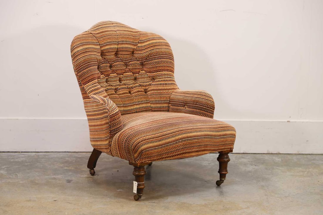 A Victorian armchair, by Cornelius V Smith: A Victorian armchair, by Cornelius V Smith with a shaped button tufted back above padded scroll arms and an overstuffed seat, upholstered in a striped woven fabric, raised on turned legs terminating b