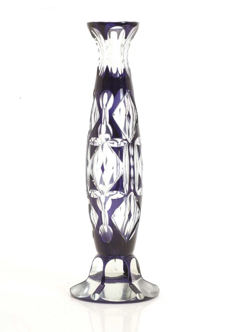 A Bohemian blue flashed and a cut glass vase, 20th century,: A Bohemian blue flashed and a cut glass vase, 20th century, of slender baluster form with flared rim, deeply cut with stylised leaf and diamond motifs reserved to a rich cobalt blue ground, raised on