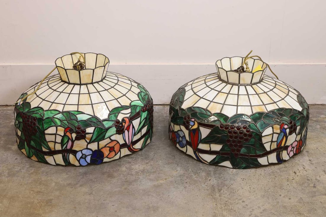 A pair of stained glass style lamp shades, by Christopher Wray,: A pair of stained glass style lamp shades, by Christopher Wray, with stained glass effect decorated with flowers and berries 63cm diameter, 34cm high 2 Condition Report: We cannot guarantee the full